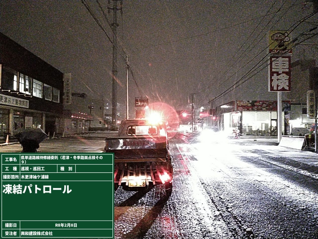 空が暗い時間にトラックが道路を走行している写真
